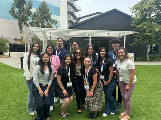 Group photo of Acadia interns and team members standing together on a green lawn in front of office buildings, symbolizing collaboration and company culture