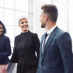 Diverse business team walking and talking together in a modern office setting, reflecting teamwork and collaboration