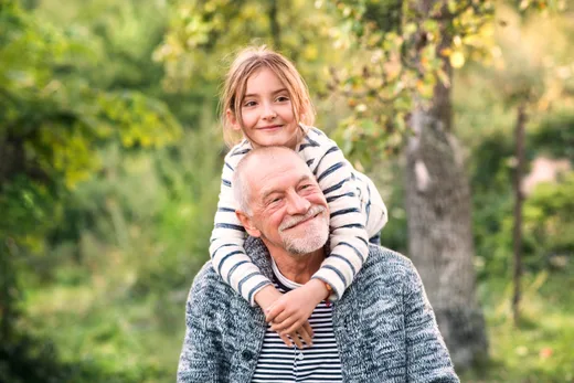 Grandfather giving granddaughter a piggy back ride